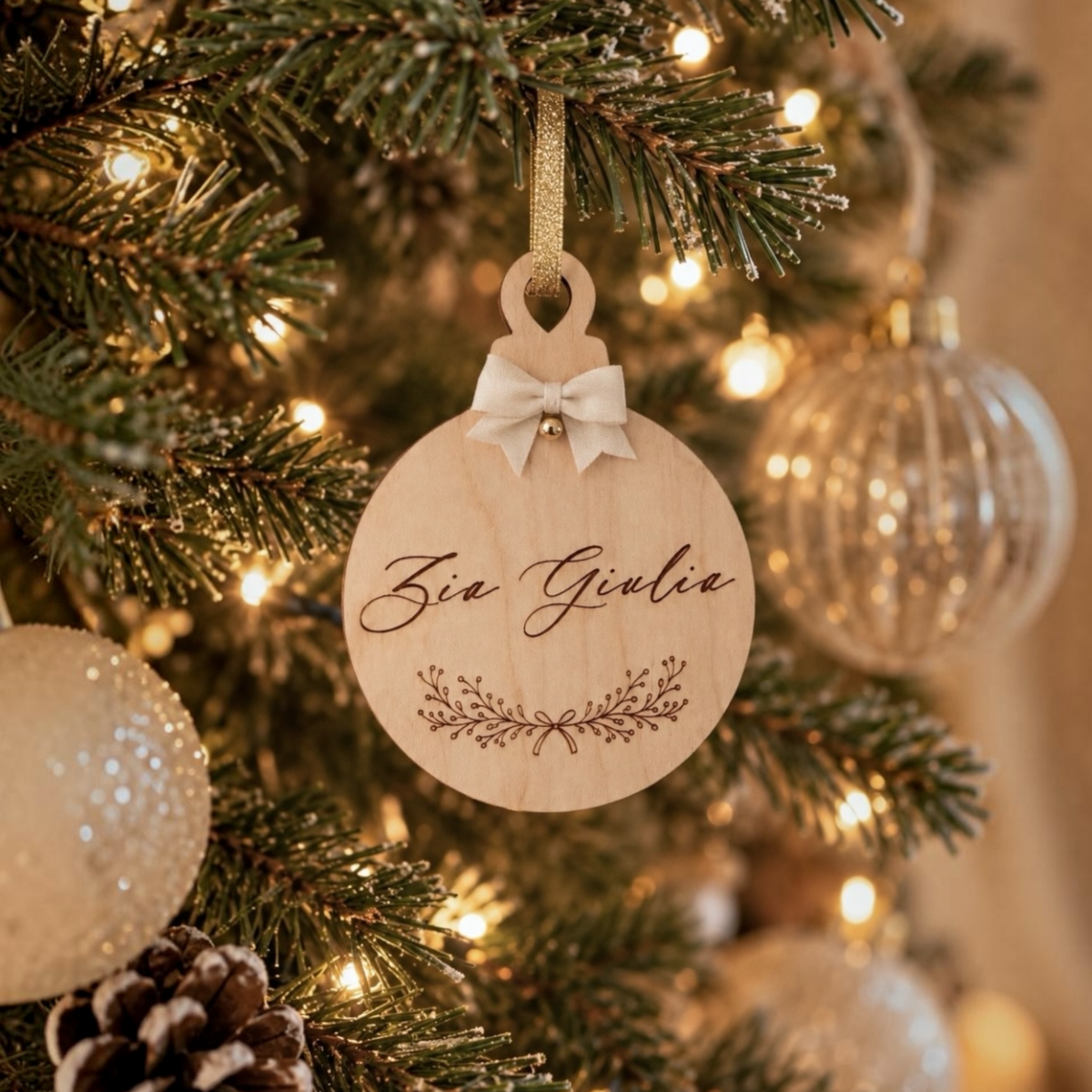 Dettaglio della pallina di Natale personalizzata chiusa e appes all'abero con messaggio sorpresa vuoi essere la mia madrina o il mio padrino.