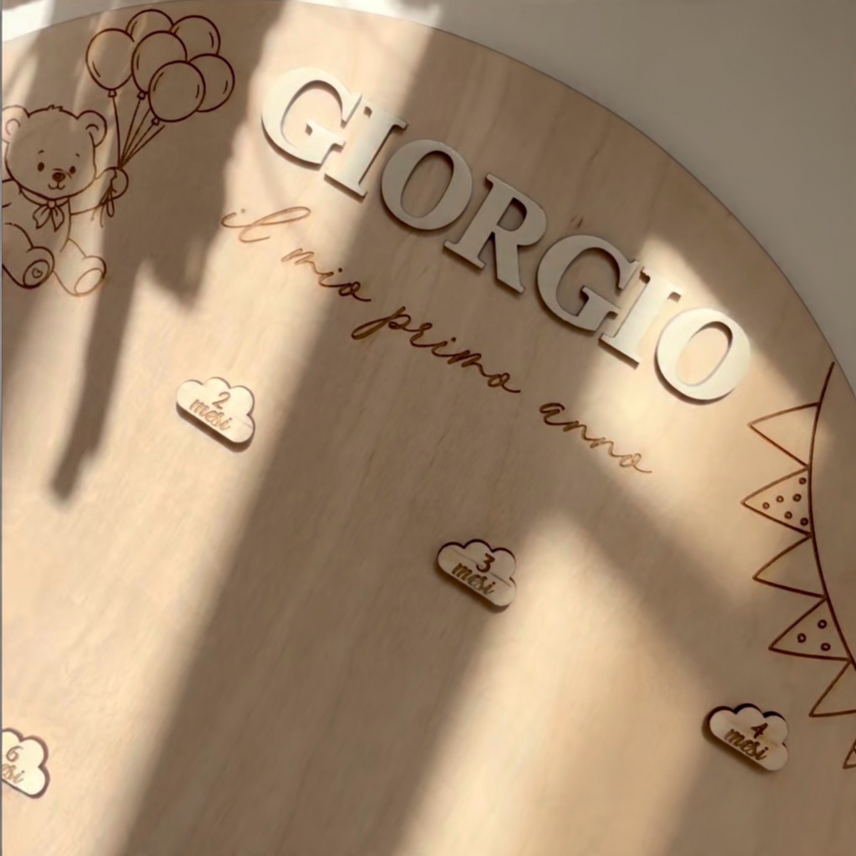Primo piano del nome Giorgio in legno applicato in rilievo sul portafoto Teddy, con incisione il mio primo anno e dettagli decorativi.
